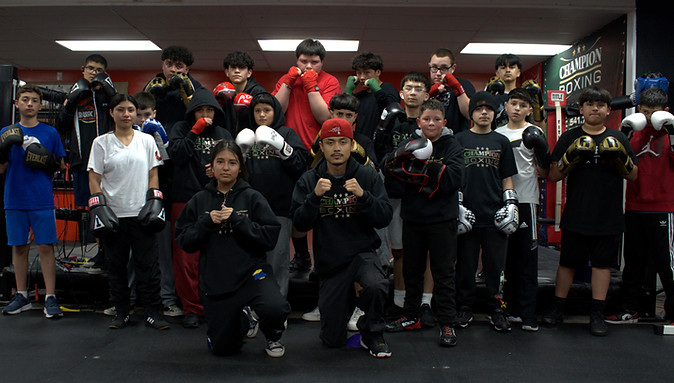 Two boxers sparring in the ring at Champion Boxing